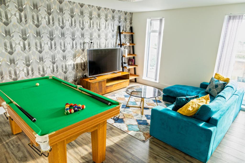 a living room with a pool table and a couch at Attractive 2 Bedroom Penthouse with free Parking in Romford