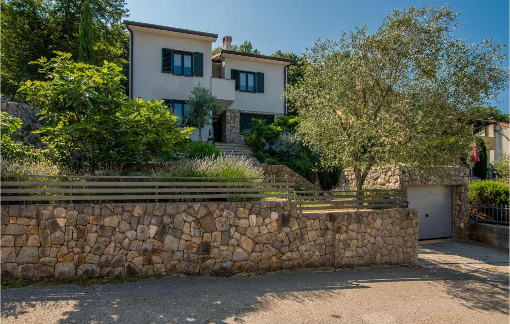 a villa with a stone wall and a house at Beautiful Apartment In Porozina With 4 Bedrooms And Wifi in Porozina