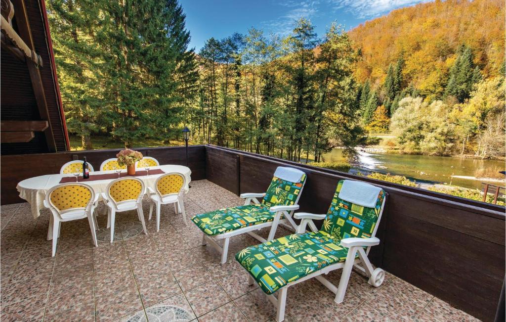 un patio con mesa y sillas y vistas al río en 2 Bedroom Cozy Home In Brod Na Kupi, en Brod na Kupi