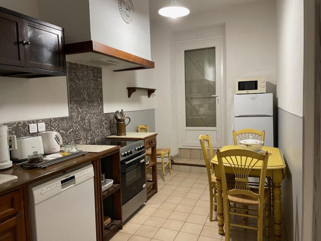 - une cuisine avec une table, des chaises et un comptoir dans l'établissement le Cocooning Marseillais, à Marseille