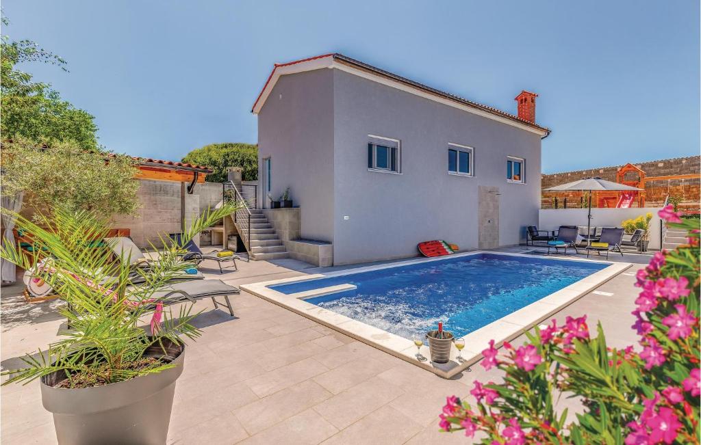 uma villa com piscina em frente a uma casa em Gorgeous Apartment In Pula With Kitchen em Muntić