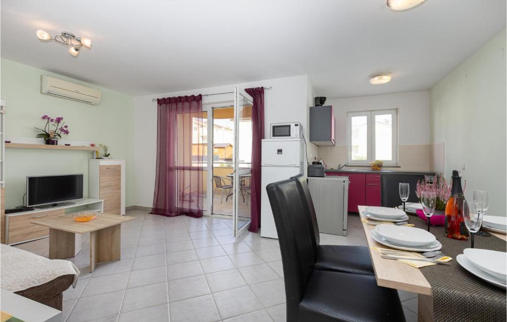 a kitchen and living room with a dining room table and a kitchen at Beautiful Apartment In Cizici With Wifi in Čižići