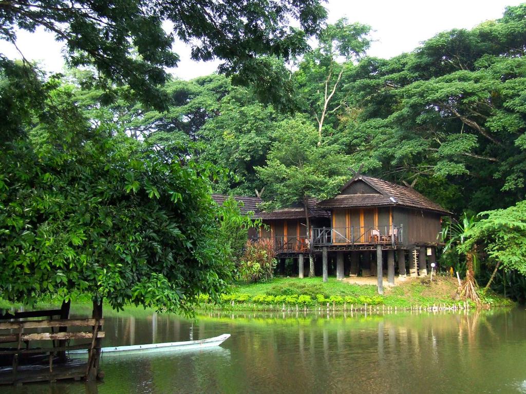 een huis aan de oever van een waterlichaam bij Lampang River Lodge - SHA certified in Lampang