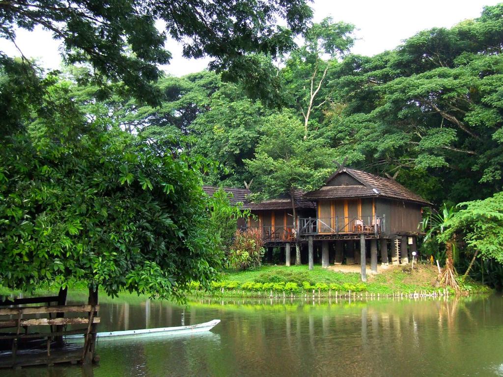 una casa en la orilla de un cuerpo de agua en Lampang River Lodge - SHA certified, en Lampang