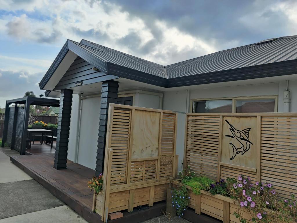 una casa con una valla de madera en una terraza en Holiday Home in Papamoa, en Tauranga