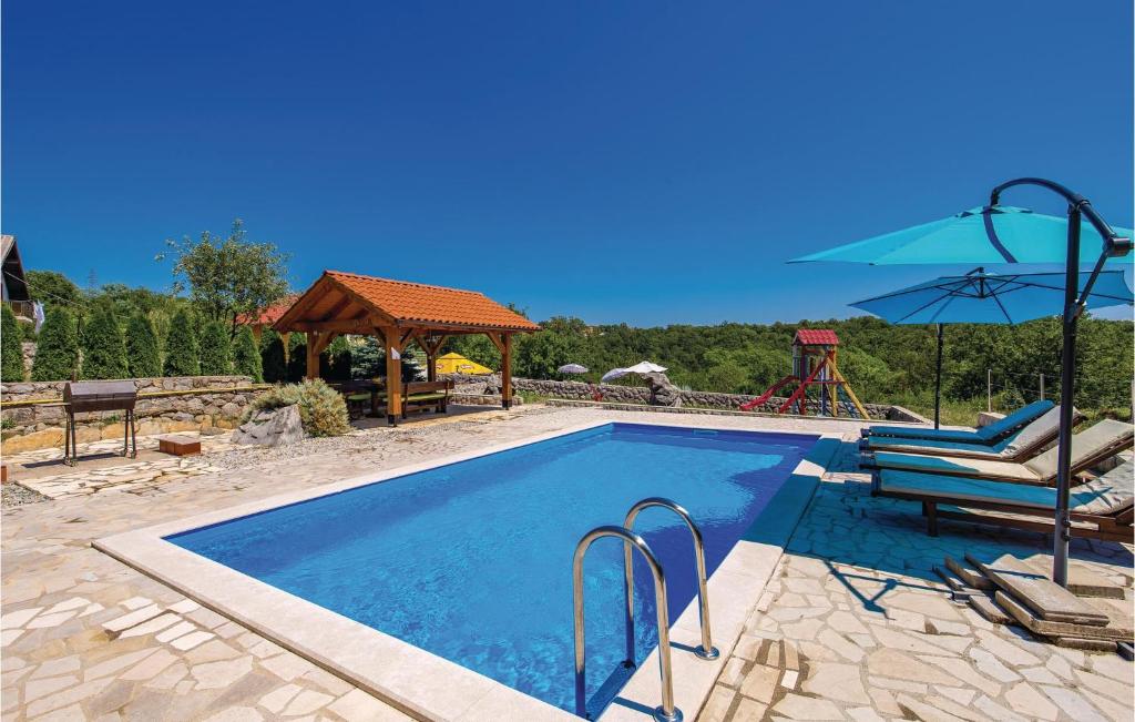 a swimming pool with a chair and umbrella and a playground at Awesome Home In Viskovo With 4 Bedrooms, Wifi And Outdoor Swimming Pool in Bezjaki