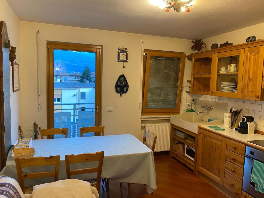 cocina con mesa, fregadero y ventana en CASA DI PITTO, en Bresanona