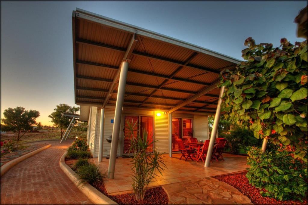 a house with a covered porch with a building at Samson Beach Chalets in Point Samson