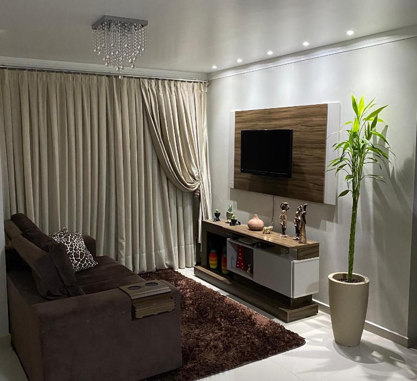 uma sala de estar com um sofá e uma televisão em Apartamento em Pomerode em Pomerode