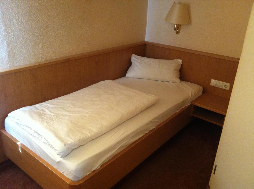a small bed in a room with a night stand at Hotel Ochsen Kehl-Kork in Kehl am Rhein