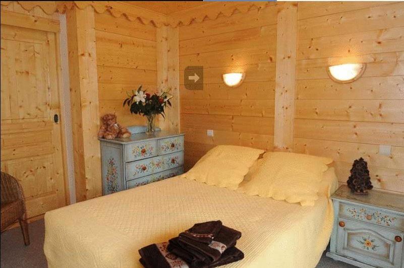 une chambre avec un lit dans une pièce en bois dans l'établissement Résidence Les Glaciers, à Samoëns