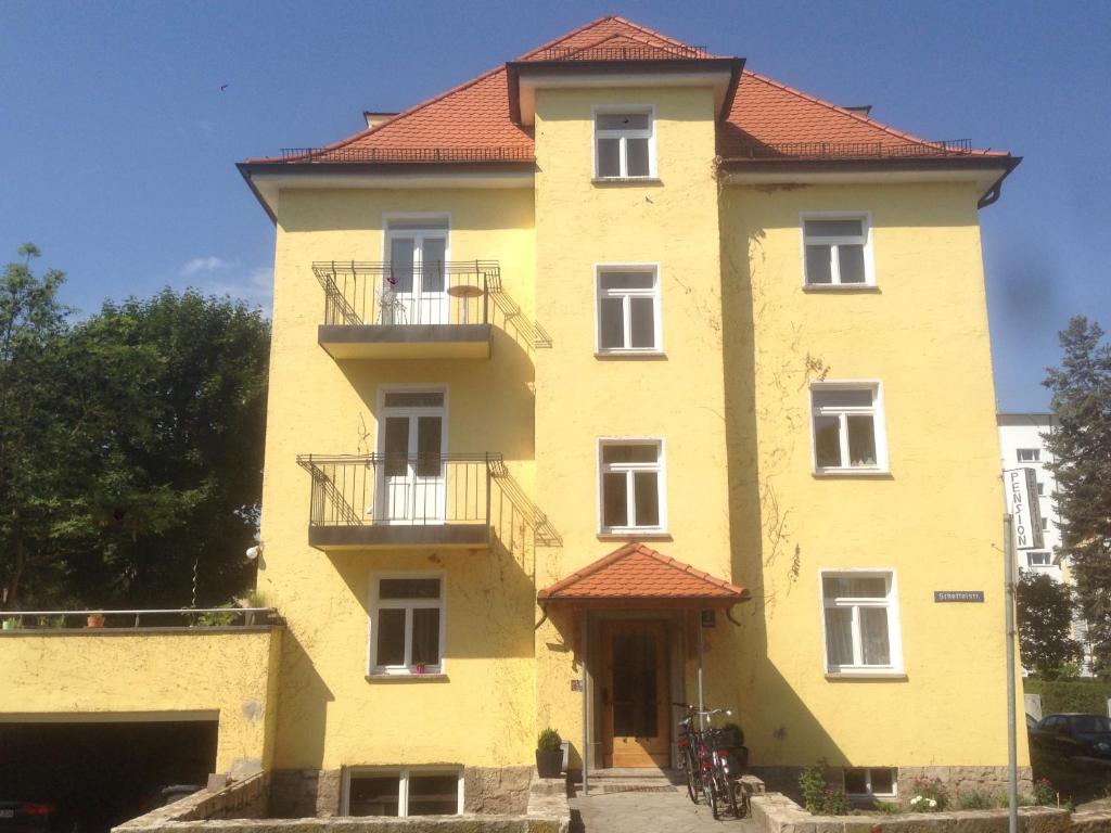 ein großes gelbes Gebäude mit rotem Dach in der Unterkunft Achtzimmer in Würzburg