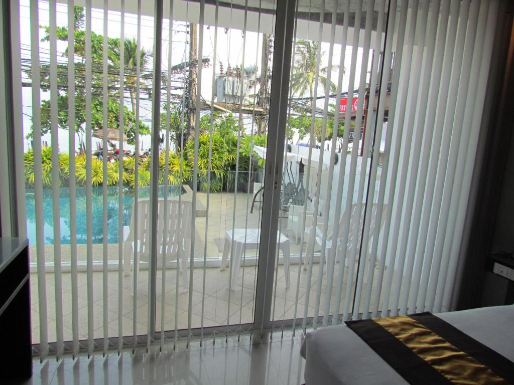 a bedroom with a sliding glass door to a pool at The Front Hotel and Apartments in Patong Beach