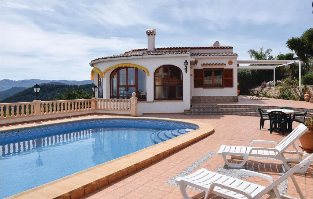 eine Villa mit einem Pool und einem Haus in der Unterkunft 3 Bedroom Beautiful Home In Oliva in Oliva