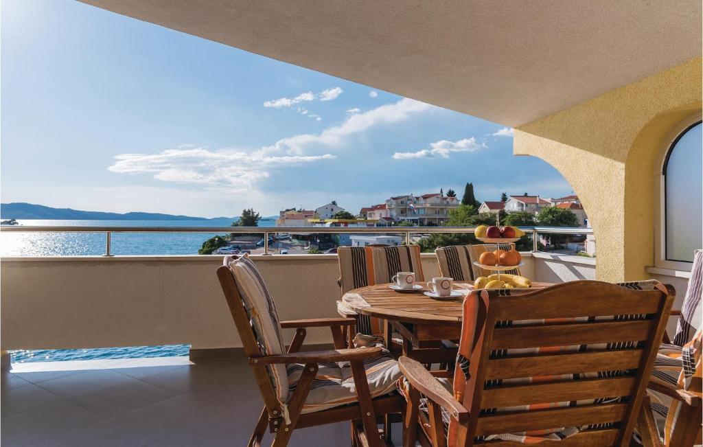 einen Tisch und Stühle auf einem Balkon mit Blick auf das Wasser in der Unterkunft Nice Home In Sibenik With Kitchen in Šibenik