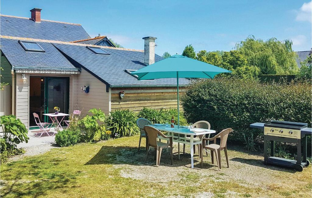 a table and chairs with an umbrella and a grill at Gorgeous Home In Mont-Dol With Wifi in Mont-Dol