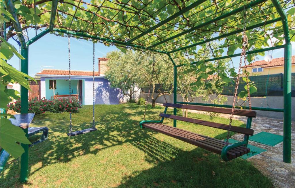 a swing in a yard with a house at 1 Bedroom Beautiful Apartment In Liznjan in Ližnjan