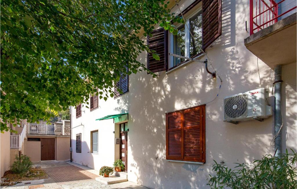 a white building with red shutters and a window at Beautiful Apartment In Jablanac With Wifi in Jablanac