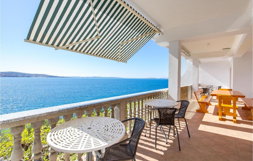 balcón con mesa, sillas y vistas al océano en Amazing Apartment In Prizna With Kitchen, en Prizna