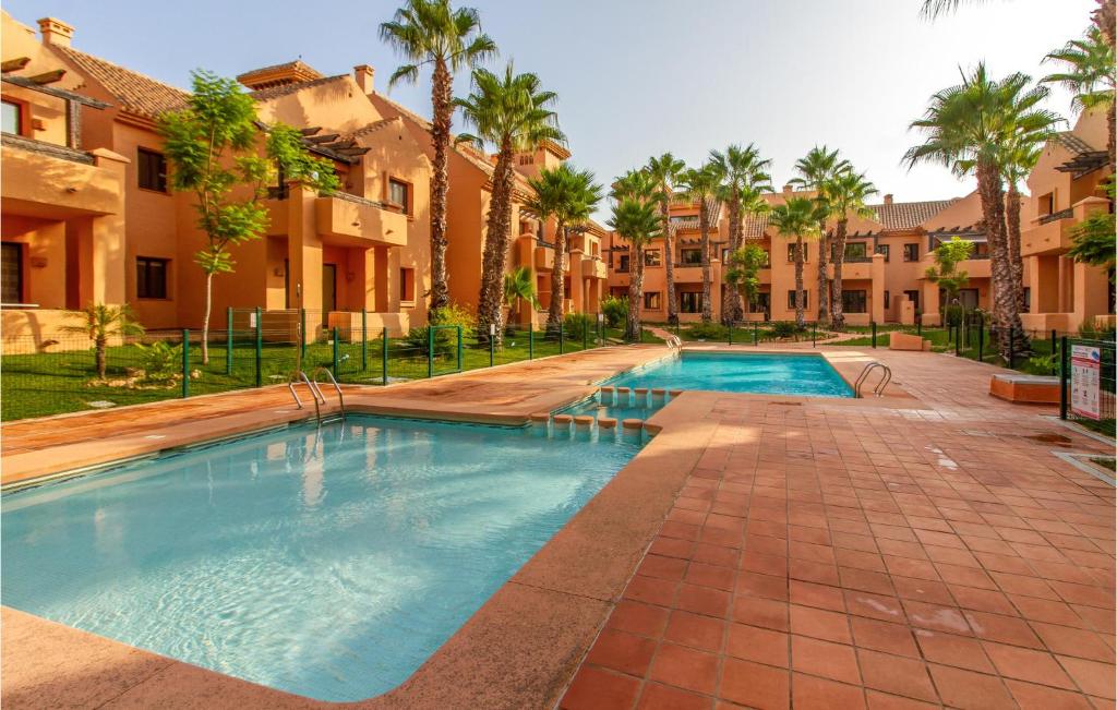 una piscina in un cortile con palme di Lovely Apartment In Los Narejos With Wifi a Los Narejos