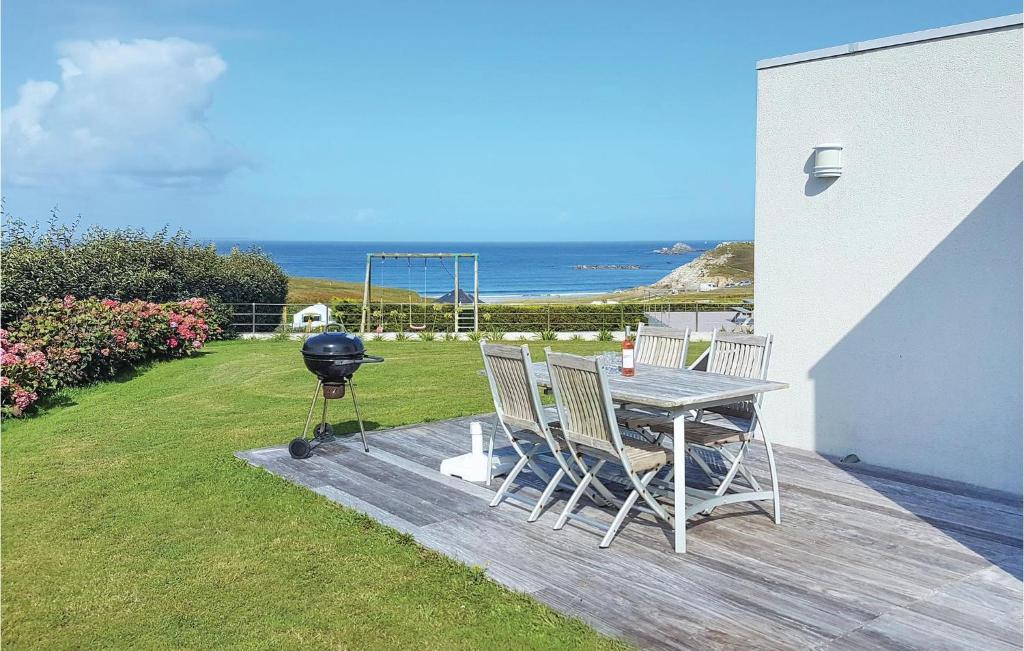 een grill en een tafel en stoelen op een terras bij Beautiful Home In Plouarzel With Indoor Swimming Pool in Rubian