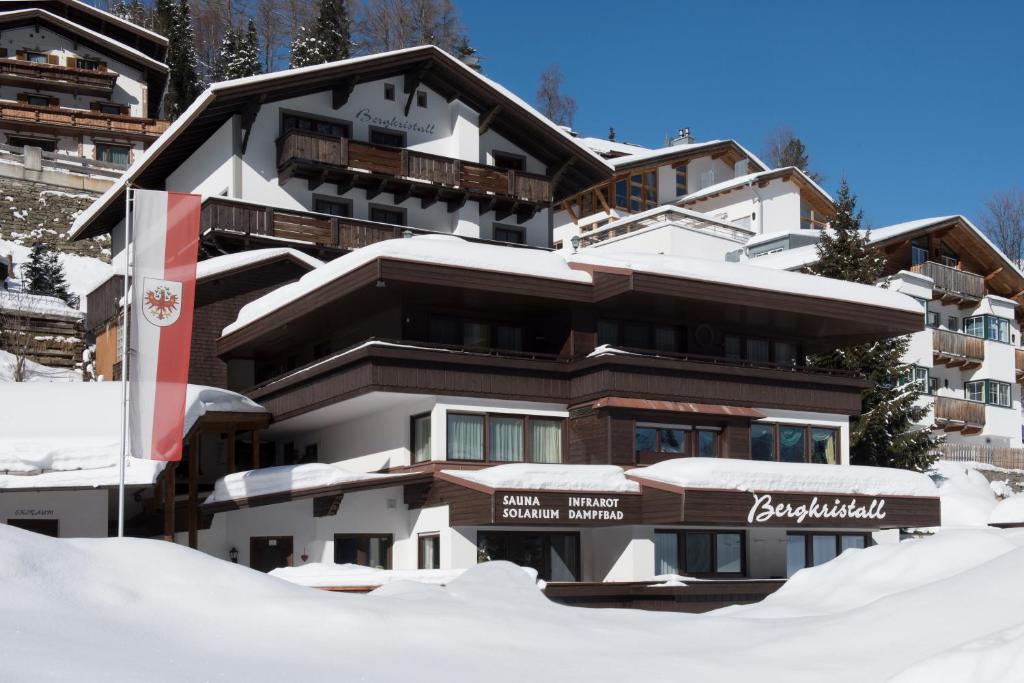 un edificio cubierto de nieve con nieve alrededor en Haus Bergkristall, en Sankt Anton am Arlberg