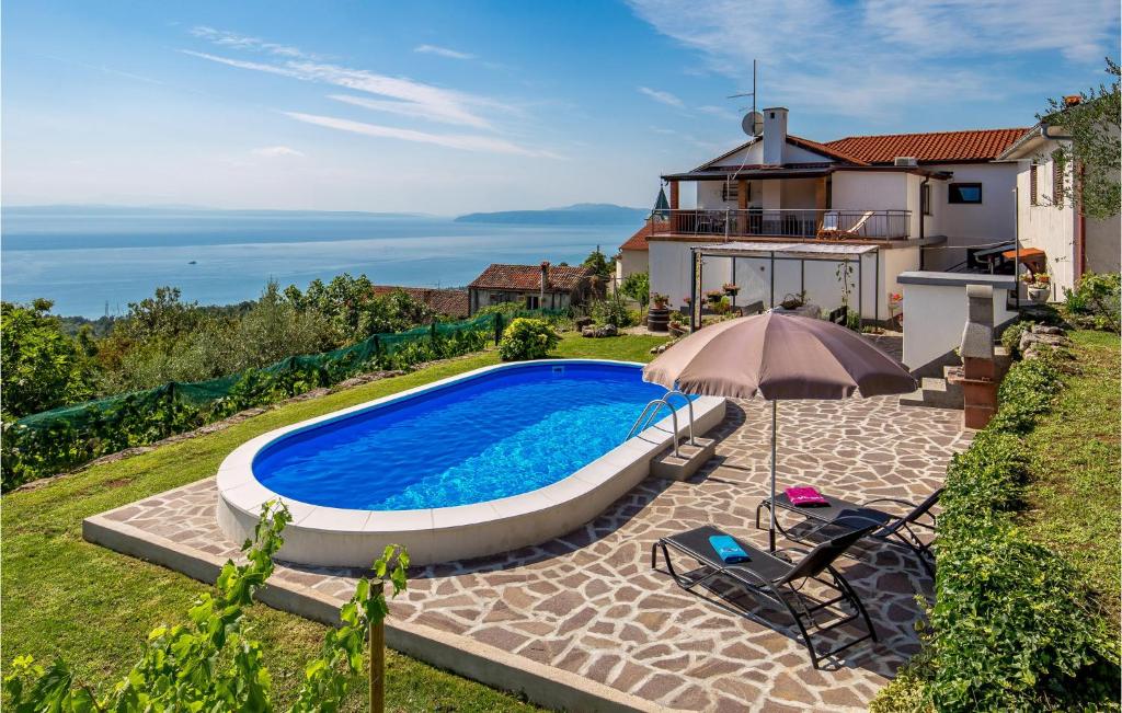 uma casa com piscina e guarda-sol em Amazing Apartment In Icici With Kitchen em Ičići