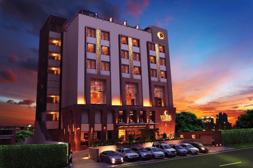 Hotel Vrisa في جايبور: مبنى فيه سيارات متوقفة في موقف للسيارات