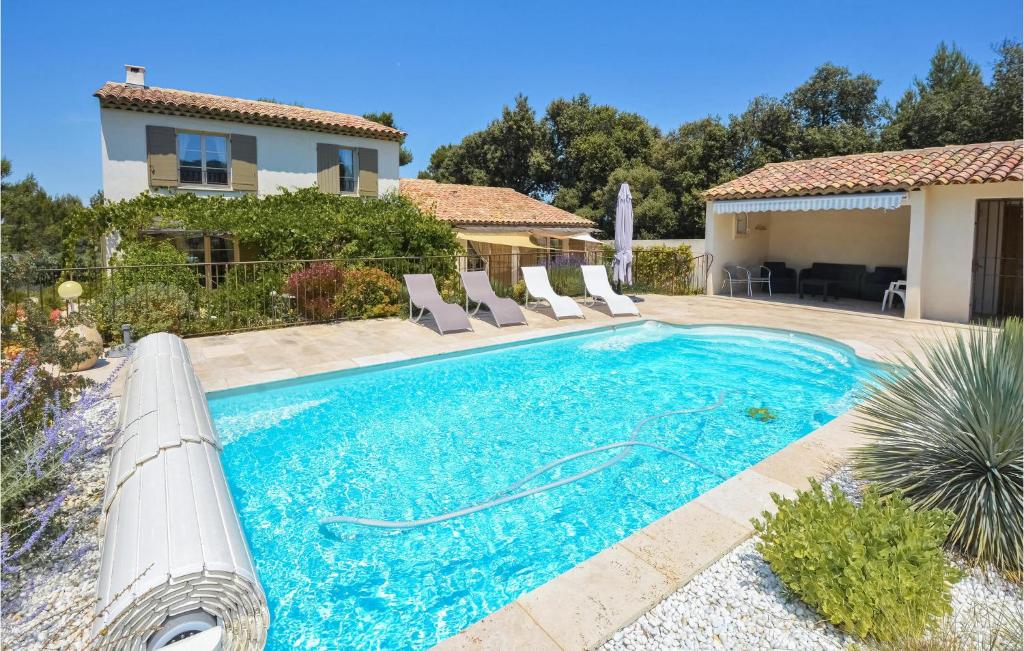 a swimming pool with chairs and a house at Beautiful Home In Eygalires With 4 Bedrooms, Wifi And Outdoor Swimming Pool in Eygalières