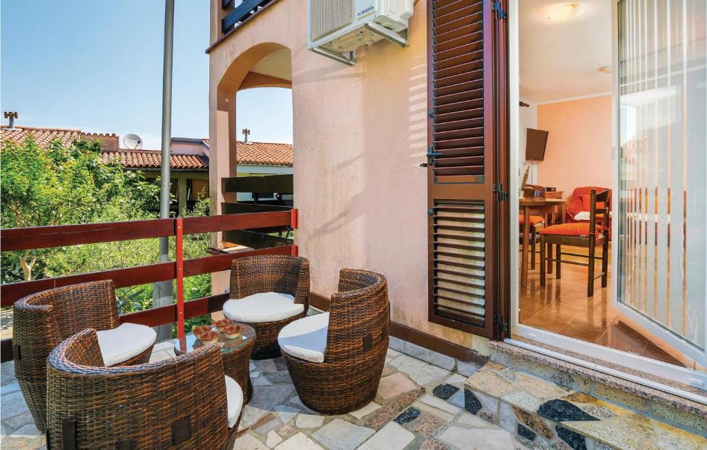 a patio with chairs and a table on a balcony at 1 Bedroom Pet Friendly Apartment In Labin-ravni in Ravni