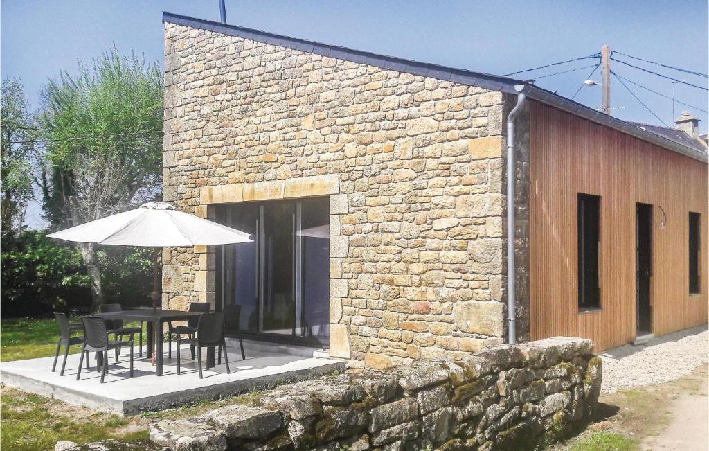 Un edificio de piedra con una mesa y una sombrilla. en Stunning Home In Erdeven With Wifi, en Erdeven