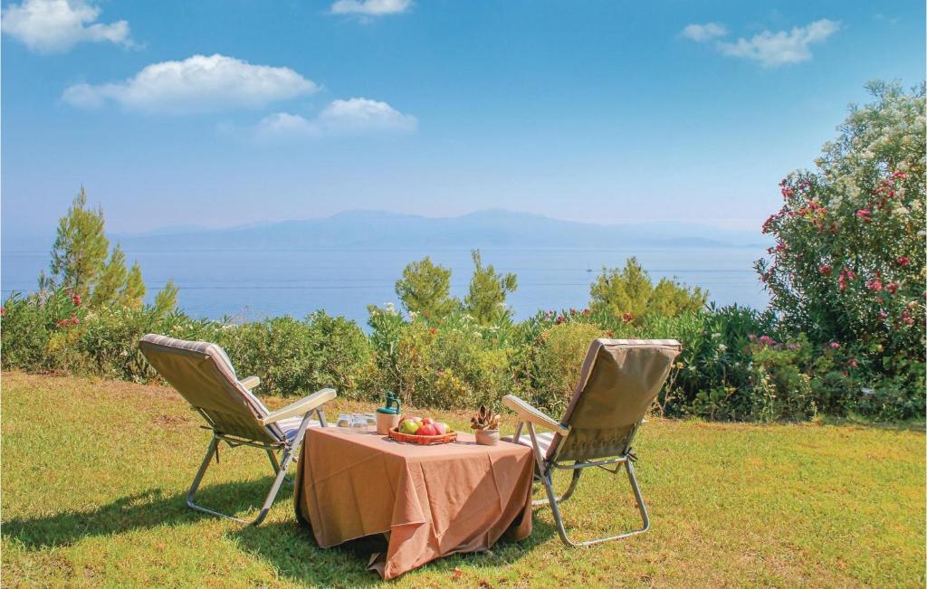 2 Stühle und ein Tisch mit Obst drauf in der Unterkunft Awesome Home In Melissi Xylokastro With House Sea View in Melíssion