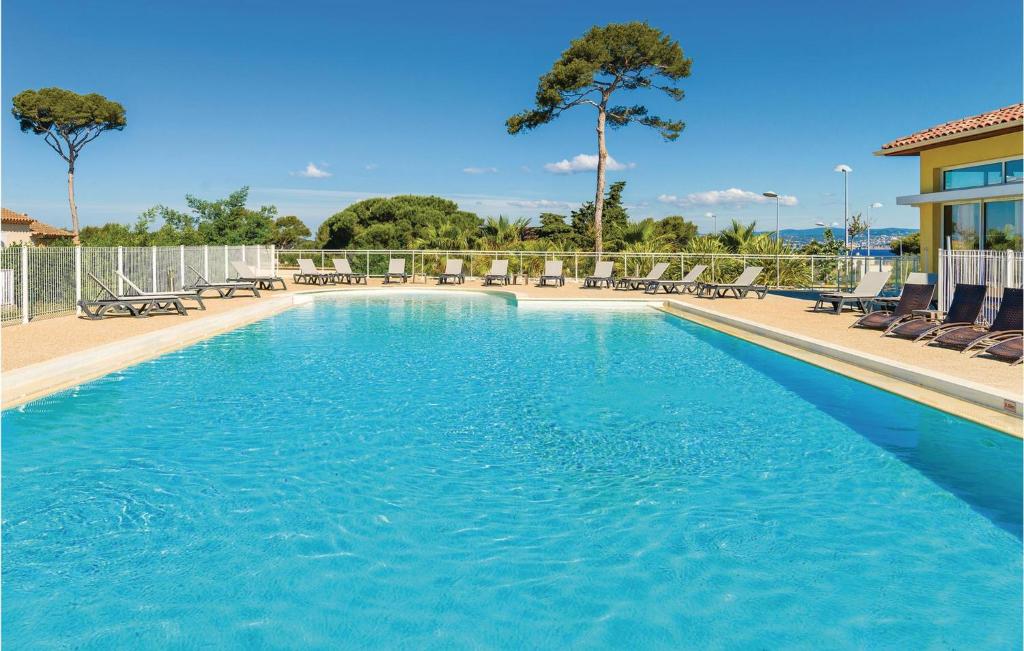 a large swimming pool with blue water and chairs at Les Terrasses Des Embiez in Six-Fours-les-Plages