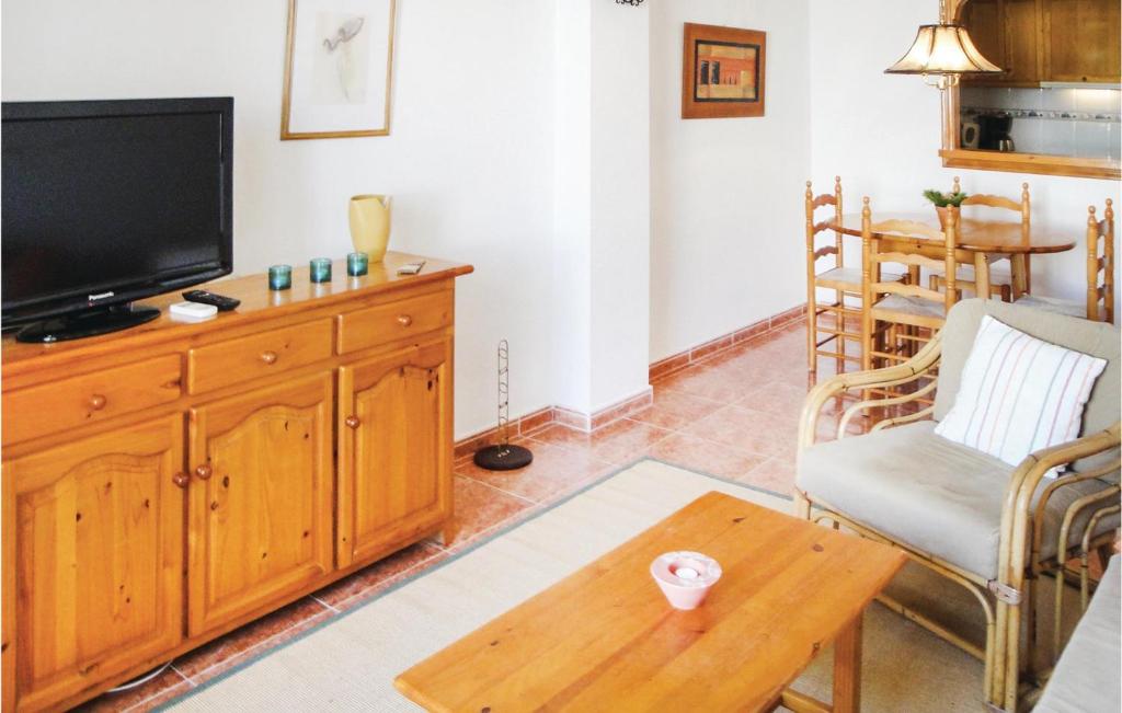 a living room with a television and a table at 2 Bedroom Cozy Apartment In Torrevieja in Torrevieja