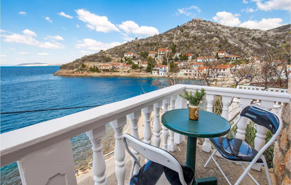 a balcony with a table and chairs and the ocean at Cozy Apartment In Starigrad With House Sea View in Starigrad