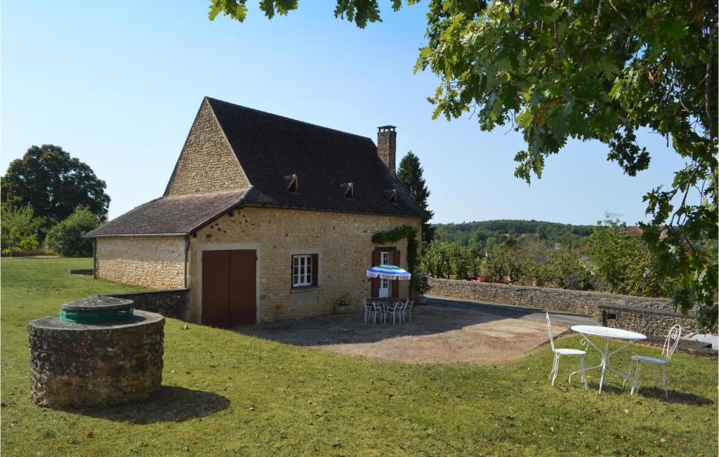 a building with a table and chairs in front of it at Nice Home In Val-de-louvre-et-caude With House A Panoramic View in Saint-Alvère