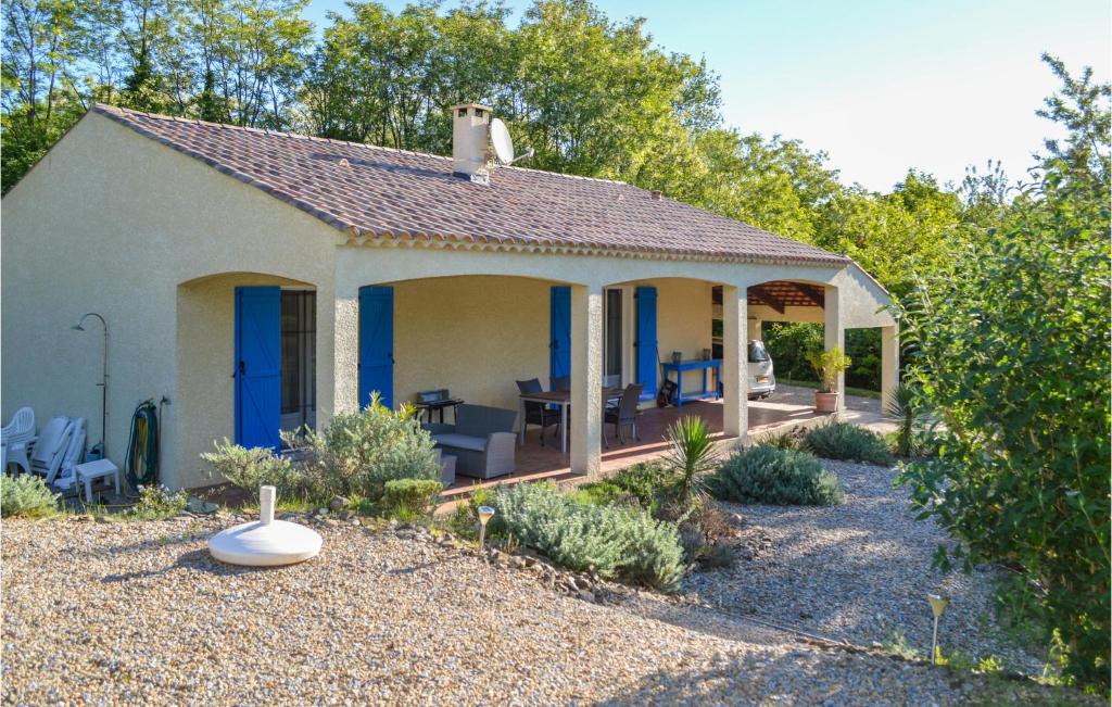 una piccola casa con porte blu e un patio di Cozy Home In Le Poujol Sur Orb With Private Swimming Pool, Can Be Inside Or Outside a Le Poujol-sur-Orb