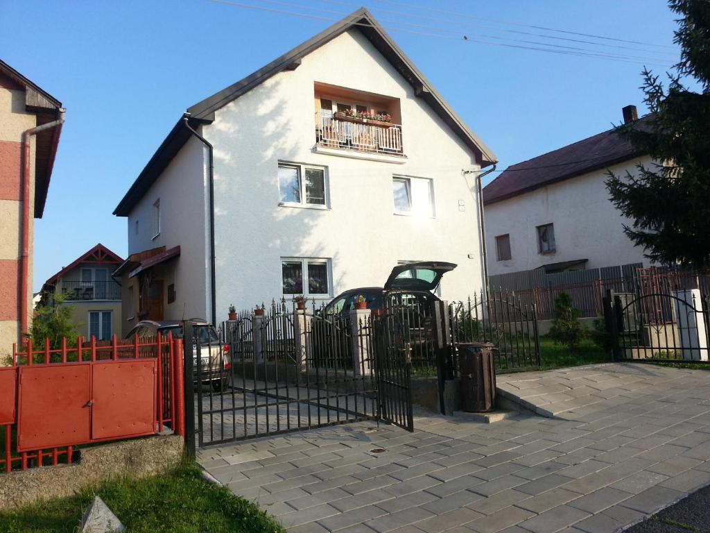 a white house with a fence in front of it at Ubytovanie u Vlasty in Štrba