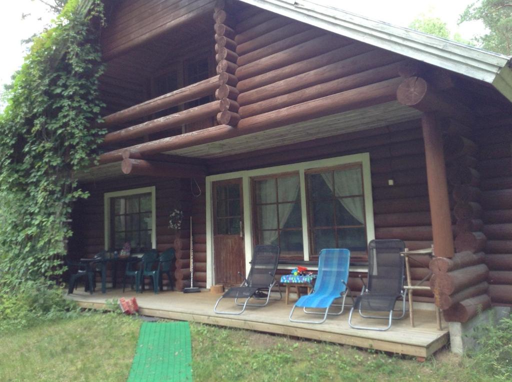 a cabin with chairs and a table on a porch at Unien Koti Cottage in Mattila