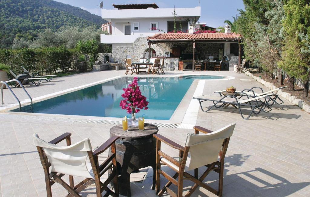 a patio with a table and chairs next to a pool at Nice Home In Agia Marina Aigina With Kitchen in Agia Marina Aegina