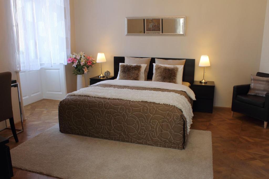 ein Schlafzimmer mit einem großen Bett und einem Stuhl in der Unterkunft Royal Prague Apartment Celakovskeho Sady in Prag