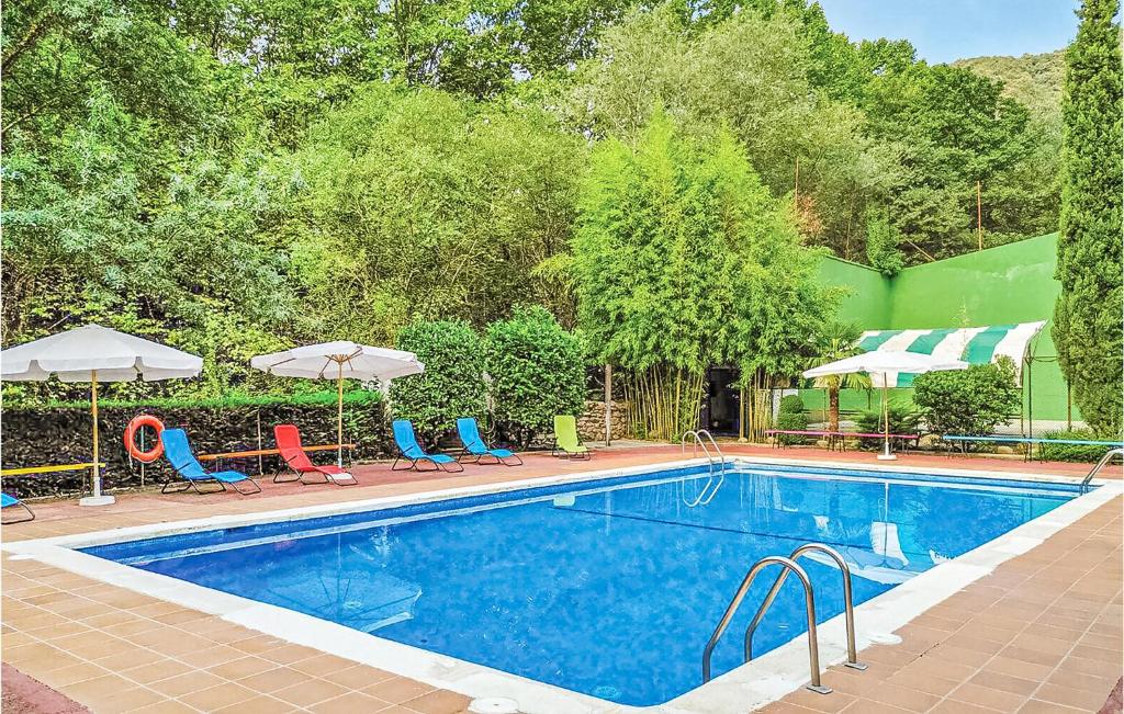 una gran piscina con sillas y sombrillas en Nice Apartment In Osor With 2 Bedrooms, Wifi And Outdoor Swimming Pool, en Osor