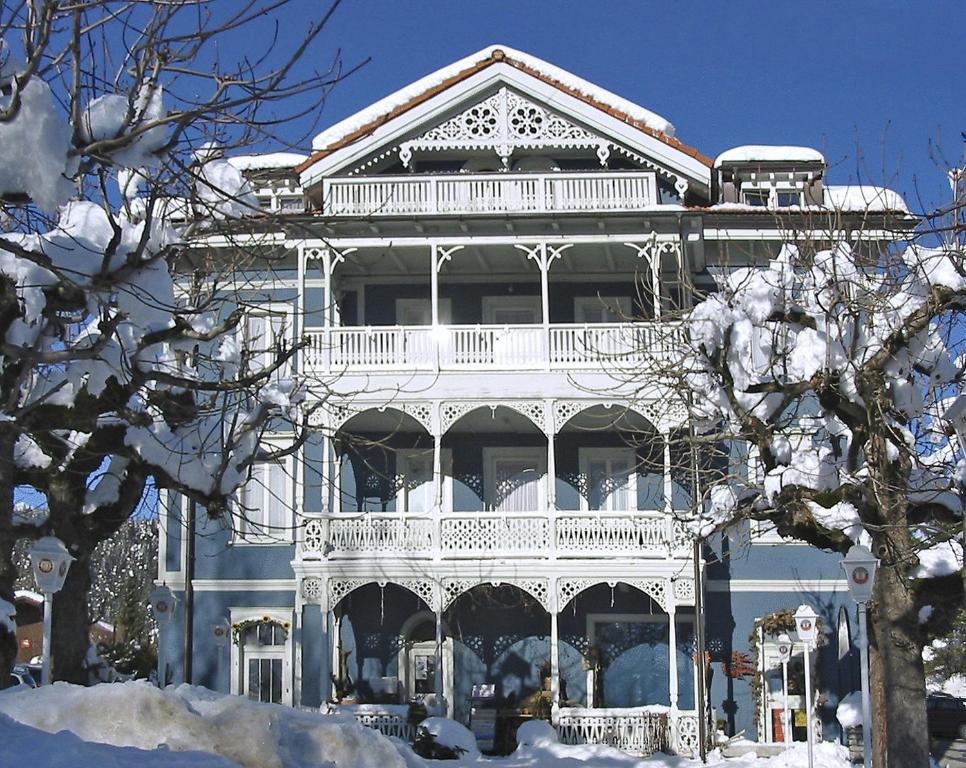 um grande edifício branco com uma grande varanda em Hotel-Gasthof Seehof Laax em Laax