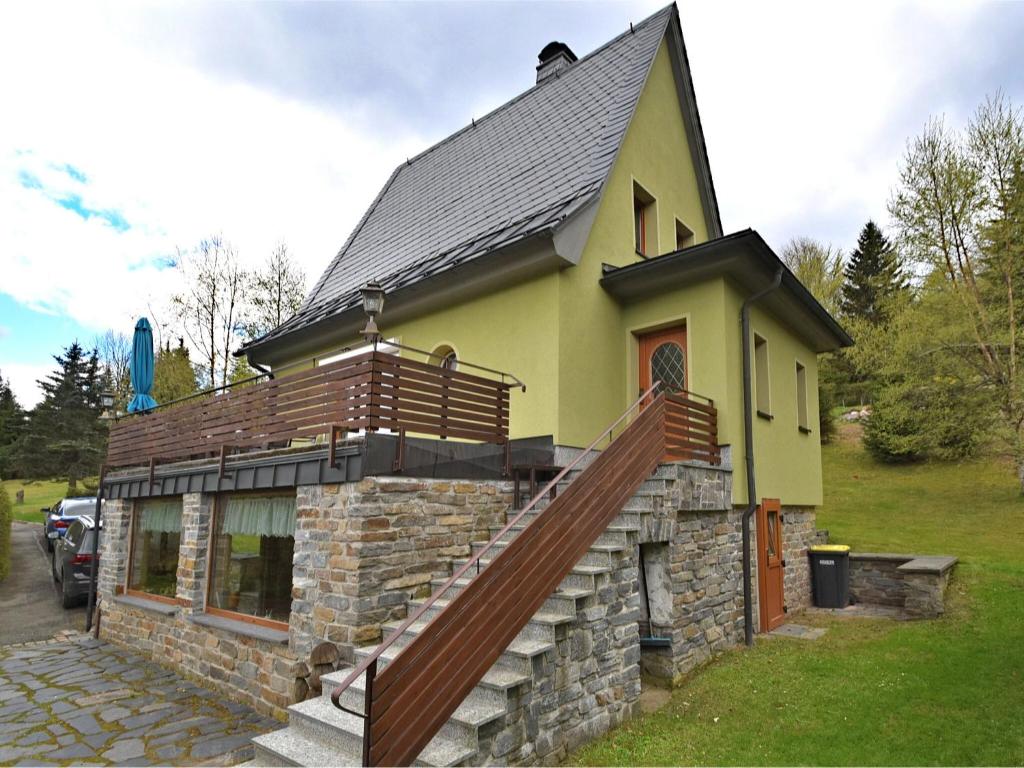 une petite maison jaune avec un escalier. dans l'établissement Holiday home with sauna in Wildenthal, à Weitersglashütte