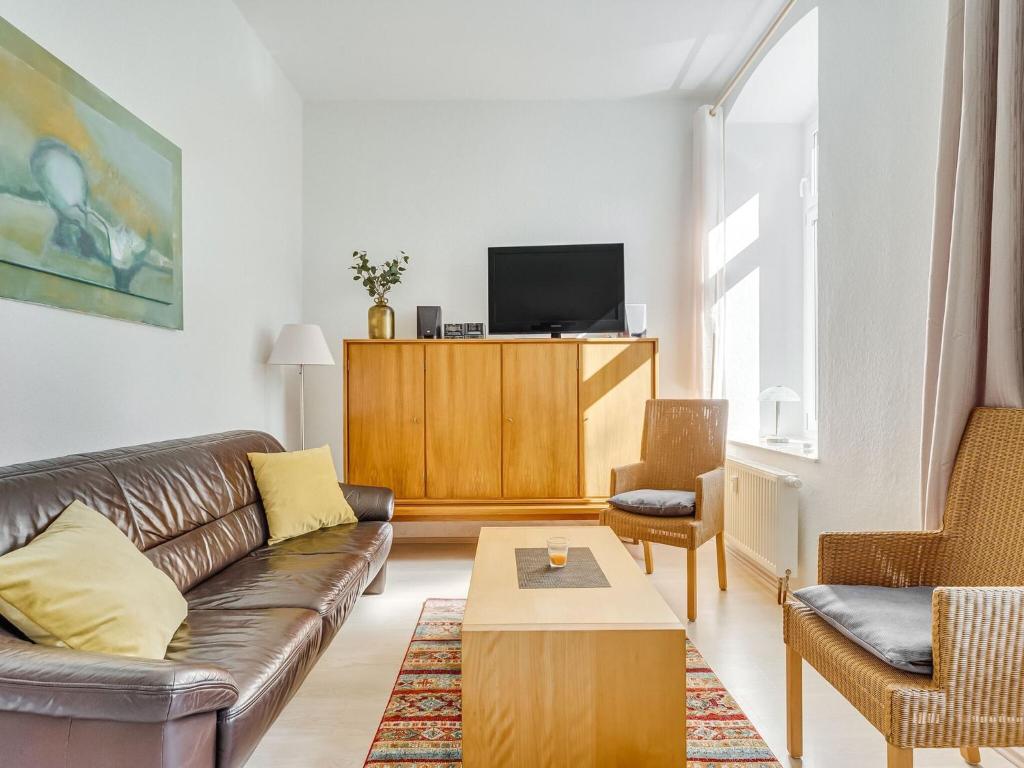 Apartment with large communal terrace في Wünschendorf: غرفة معيشة مع أريكة وتلفزيون