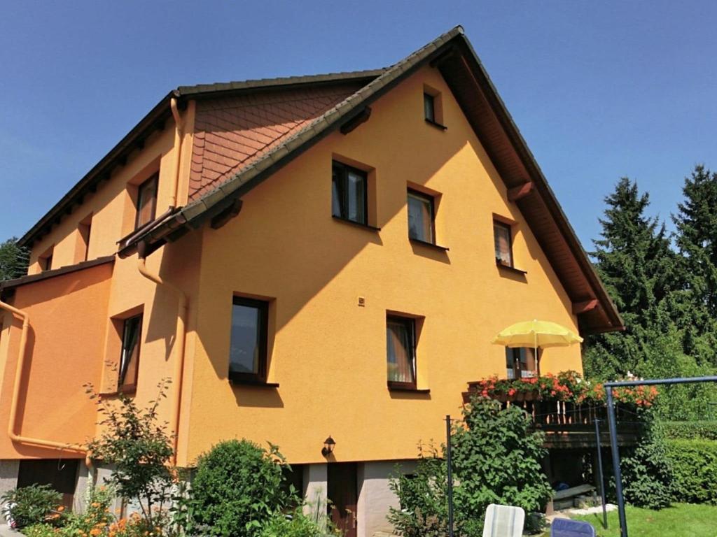 een groot geel huis met een dak bij Holiday home in the Thuringian Forest in Seligenthal