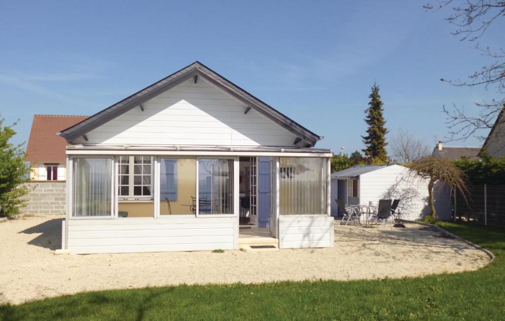 a small white shed with a large window at Beautiful Home In Bernieres-sur-mer With 1 Bedrooms in Saint-Aubin-sur-Mer