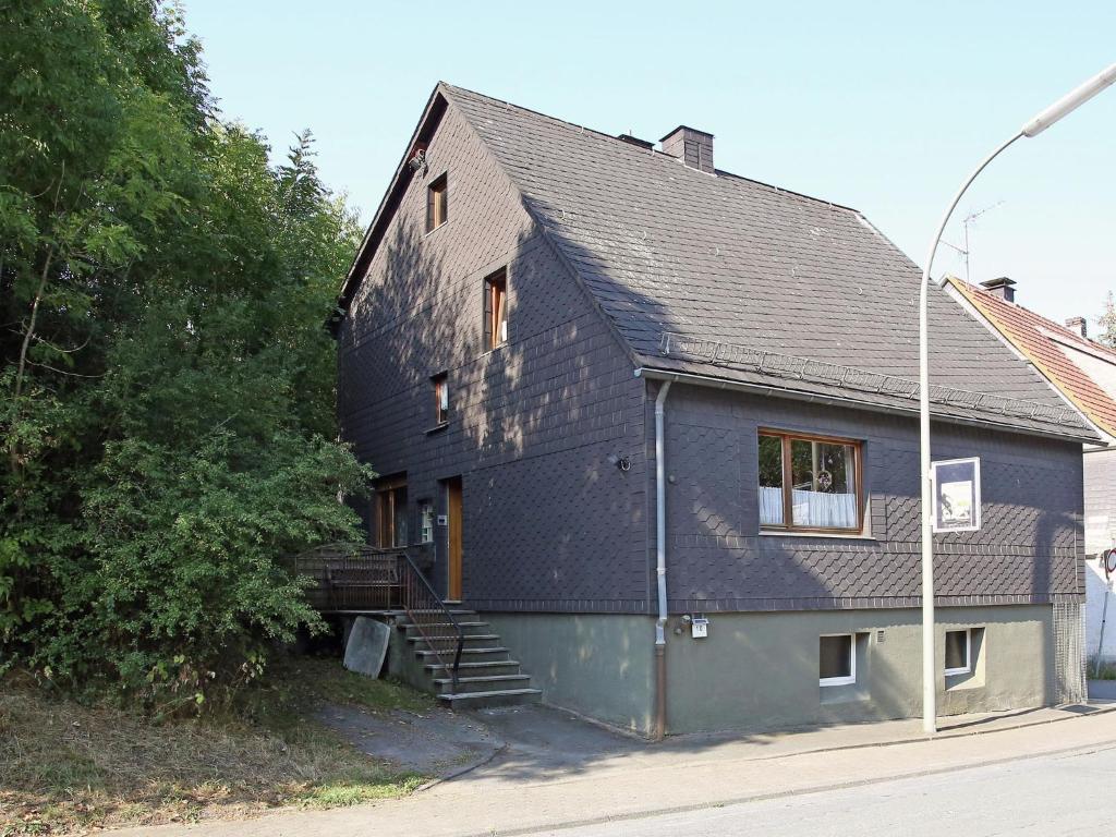 a house with a black roof and stairs on it at Secluded Apartment in Medebach with Terrace in Medebach