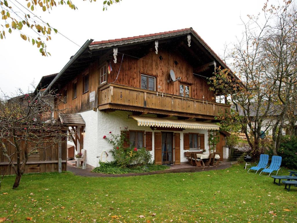 een groot houten huis met een gazon ervoor bij Spacious apartment near the ski area in Steingaden