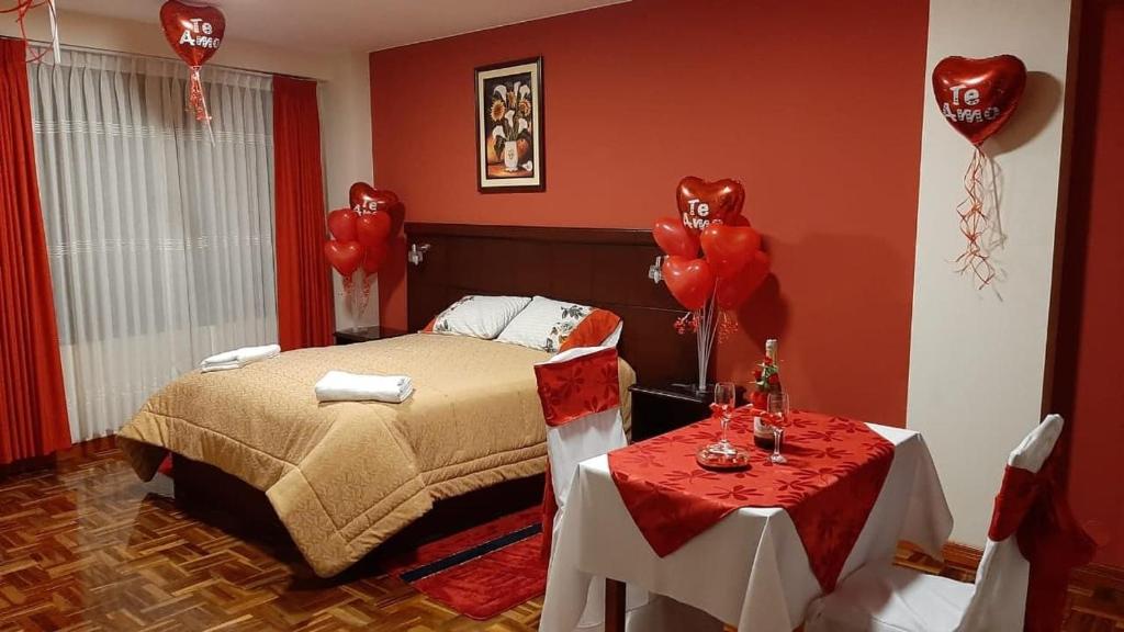 拉巴斯的住宿－Hostal Belisario，一间卧室设有红色的墙壁、一张床和气球